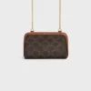 Clutch met ketting in Triomphe Canvas en lamsleer Clutch met ketting in Triomphe Canvas en lamsleer