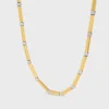 Lange ketting met bedels van messing met goud- en rhodiumafwerking