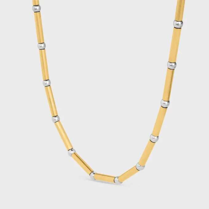 Lange ketting met bedels van messing met goud- en rhodiumafwerking