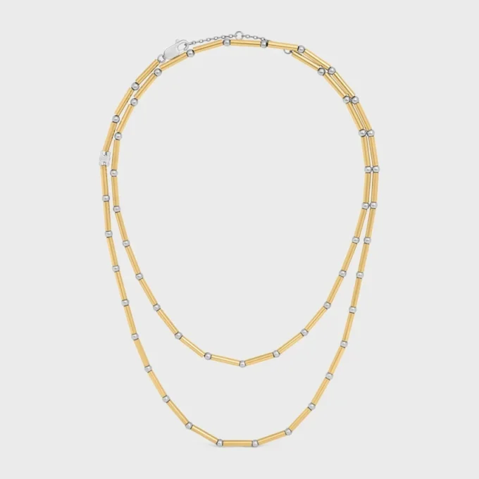 Lange ketting met bedels van messing met goud- en rhodiumafwerking