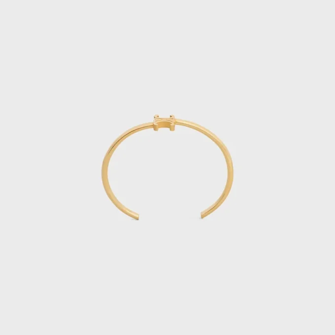 Triomphe asymmetrische manchet in messing met gouden afwerking