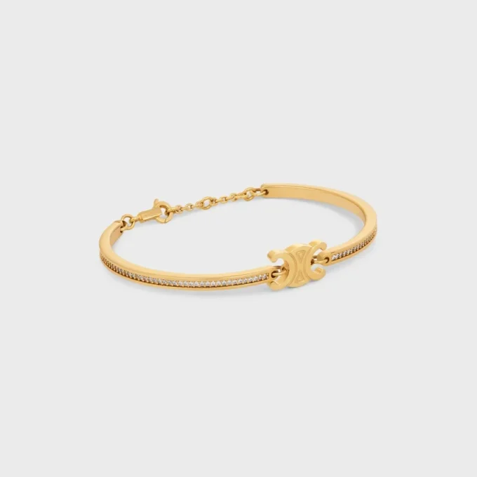 Triomphe scharnierende glinsterende armband van strass en messing met gouden afwerking
